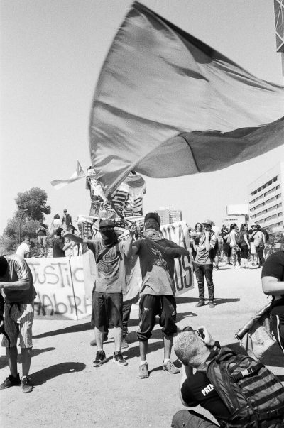 Manifestant portant un drapeau se faisant photographier 