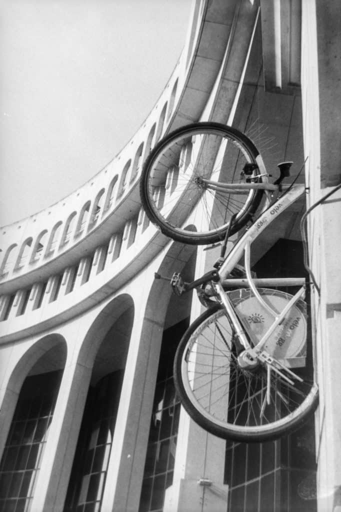 Place Zeus avec un vélo incrusté sur la façade du batiment, au cœur de l'architecture néo-classique de Ricardo Bofill à Montpellier.